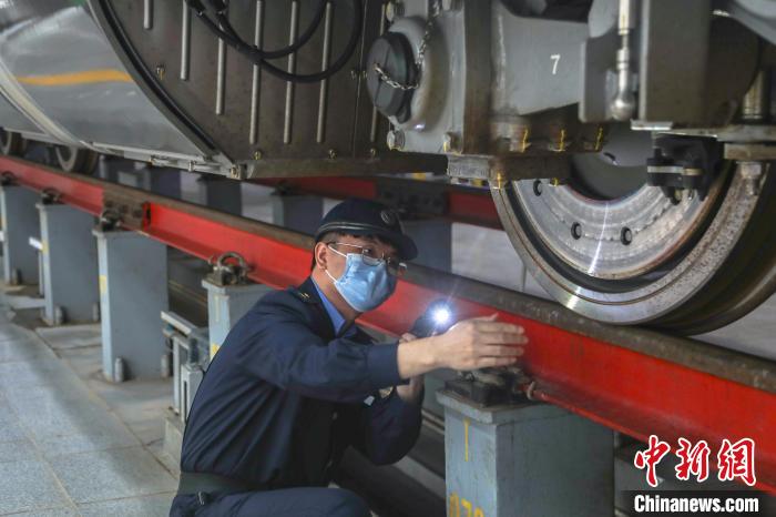图为地勤机师在南铁首批“复兴号”智能动车组的一列列车底部开展检查作业。　刘力鑫 摄
